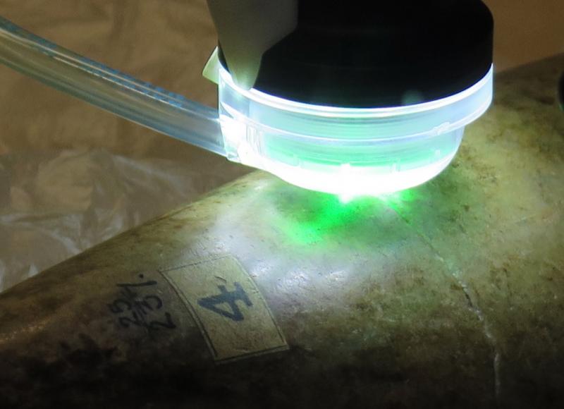 a green light shines on a stone tool
