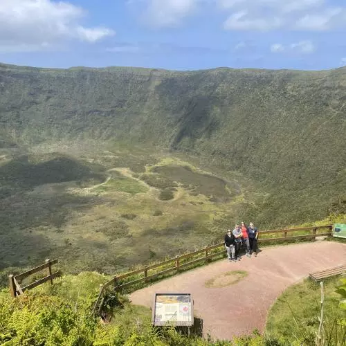 The team stand on an observation point overlooking a crater