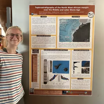 Elo stands in front of her conference poster