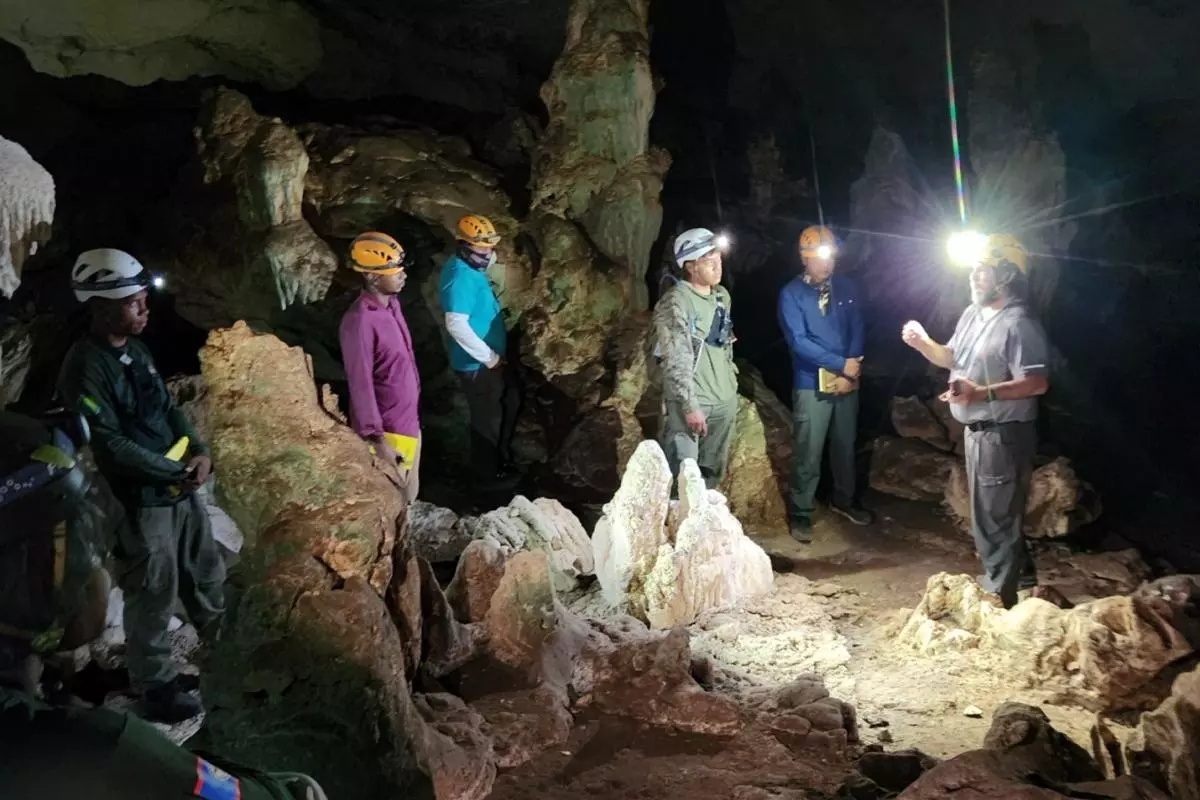Several members of the team inside one of caves, the scene is lit by their head torches